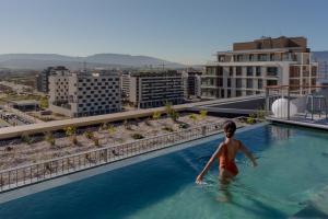 a woman in a swimming pool on top of a building at Kora Kiliki in Pamplona