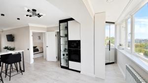 a living room with white walls and a black and white cabinet at Sunset Apartment Aktau Квартира в центре у моря in Aktau