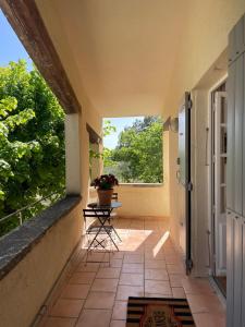 a patio with a table and chairs on a balcony at La bergerie in Grignan