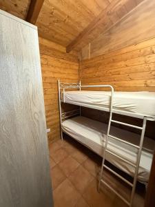 a room with two bunk beds in a wooden cabin at Campeggio Il Delfino in Rocca Imperiale