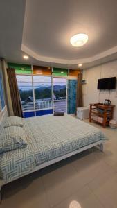 una camera da letto con un letto e una grande finestra di บ้านแช่มช้อย 360 a Khao Kho
