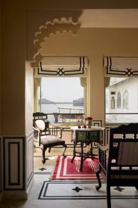 a room with a balcony with a table and chairs at Amet Haveli - A Heritage Hotel Udaipur in Udaipur