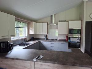 a kitchen with white cabinets and a counter top at Crescent Lodge in Forton