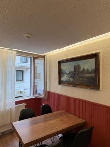 a dining room with a wooden table and two windows at elisa apart 3 in Istanbul