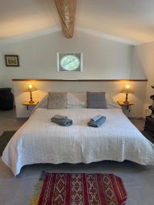 a bedroom with a large bed with two towels on it at Le cabanon de la bergerie in Grignan