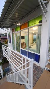 un portico anteriore di una casa con una ringhiera bianca di บ้านแช่มช้อย 360 a Khao Kho