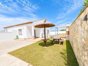 a patio with an umbrella and a table at Chalet Playa Roche in Roche