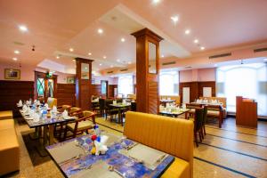 a restaurant with tables and chairs in a room at Holiday Hotel in Cherai Beach