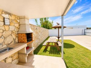an outdoor patio with a grill and an umbrella at Chalet Playa Roche in Roche