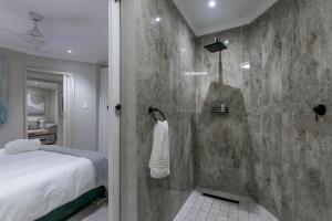 a bathroom with a shower and a bed in a room at Lagoon Point Lodge in Knysna +32 photos