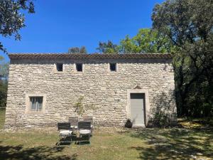 a stone building with two chairs and a door at Le cabanon de la bergerie in Grignan +6 photos