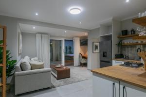 a kitchen and living room with a couch and a table at Lagoon Point Lodge in Knysna