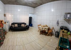 a living room with a black couch and a table at Espaço Recanto dos Sonhos DR in Itaquaquecetuba