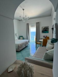 a bedroom with a bed and a living room with a table at Casa Adelaide in Capri