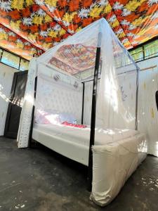 a white bed in a room with a ceiling at Baba Lao Beach Hostel in Malindi