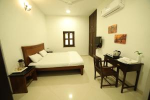 a bedroom with a bed and a desk with a telephone at Lodha Heritage in Ajmer