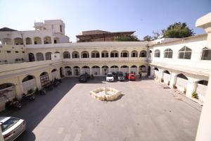 a large building with cars parked in a courtyard at Lodha Heritage in Ajmer
