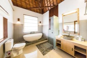 een badkamer met een bad, een toilet en een wastafel bij Villa Sekaya Ubud in Ubud