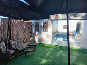 a room with chairs and an umbrella and a pool at Espaço Recanto dos Sonhos DR in Itaquaquecetuba