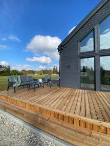 a wooden deck with two benches and a table at REAL House in Vītoliņi