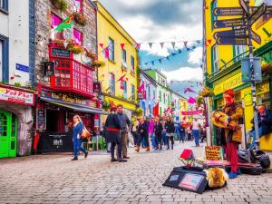 a group of people walking down a street with buildings at Dolly's Homestay in Galway