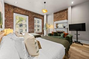 a bedroom with a large bed and a brick wall at The West 142nd Street Apartments - Manhattan NYC in New York +168 photos