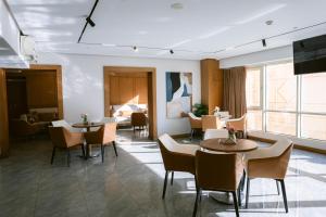 a hotel room with tables and chairs and a bed at The Grand Plaza Hotel Smouha in Alexandria