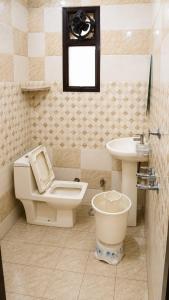 a bathroom with a toilet and a sink at Hotel Atithi Palace in Sahāranpur