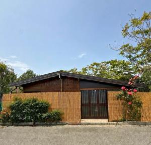 a brick house with a fence in front of it at Campeggio Il Delfino in Rocca Imperiale