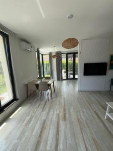a living room with a table and chairs and a television at Вила Солана - Villa Solana in Lozenets +5 photos