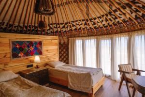 a bedroom with two beds in a room with windows at Ak-Sai Travel Oimo-Tash Yurt Camp in Kaji-Say