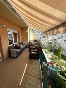 a balcony with a couch and a table at Local-Lux Premium Apartment- 2 Bedrooms Balcony -2 Private Parking in Kecskemét