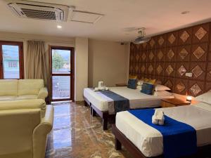 ein Hotelzimmer mit zwei Betten und einer Couch in der Unterkunft Cape Town Hotel in Nadi