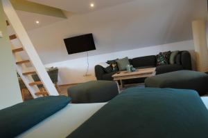 a living room with a couch and a tv at Sternennächte auf einem echtem Bauernhof in Warpke