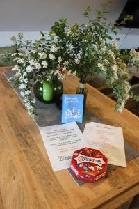 a wooden table with a vase of flowers and a box of chips at Sternennächte auf einem echtem Bauernhof in Warpke +10 photos