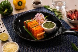a plate of food with a sandwich on a table at Grand Continent Hotel, Rameswaram in Rāmeswaram +40 photos