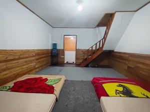 a room with two beds and a stair case at Bliss 10 people in Palayangan