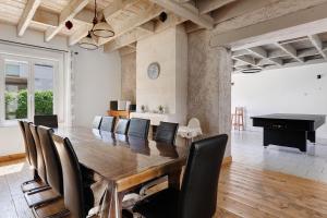 a dining room with a table and chairs and a piano at Le Gîte des Anges - 12pers, Piscine in Angé