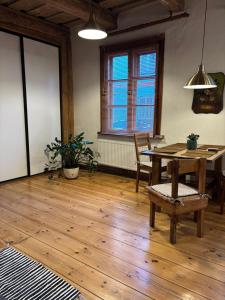 a dining room with a wooden table and a wooden floor at Central & Quiet Cēsis Stay in Cēsis +6 photos