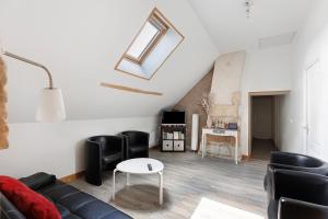 a living room with a couch and a table at Le Gîte des Anges - 12pers, Piscine in Angé