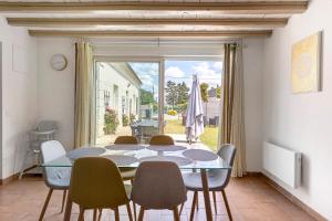 a dining room with a table and chairs and a window at Le Gîte Des Anges - 4pers, Piscine in Angé