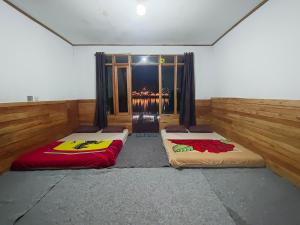 two beds in a room with a window at Bliss 10 people in Palayangan