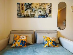 a couch with two pillows and a picture on the wall at Honigduft und Bienenluft in Sankt Oswald bei Freistadt
