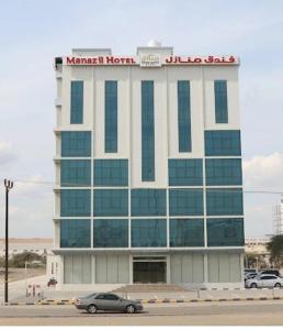 ein Gebäude mit einem Auto davor in der Unterkunft Manazil Aldar Hotel in Suhar