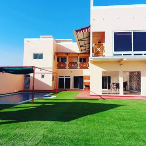 a house with a yard with a trampoline at Villa Patty by the beach in El Conacaste