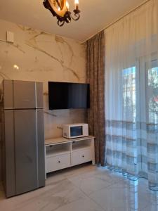 a living room with a refrigerator and a tv at Апартаменты in Hanioti