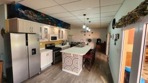 a kitchen with a refrigerator and a table in it at Villa Patty by the beach in El Conacaste