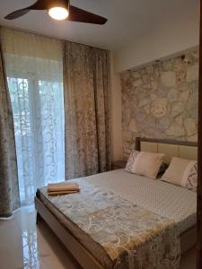 a bedroom with a large bed and a stone wall at Апартаменты in Hanioti