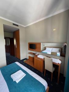 a hotel room with two beds and a desk and a television at BAR RESTORANT HOTEL ALPET Elbasan in Elbasan +24 photos