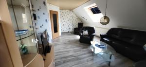 a living room with a black couch and chairs at 4 Sterne Ferien Martens in Cuxhaven